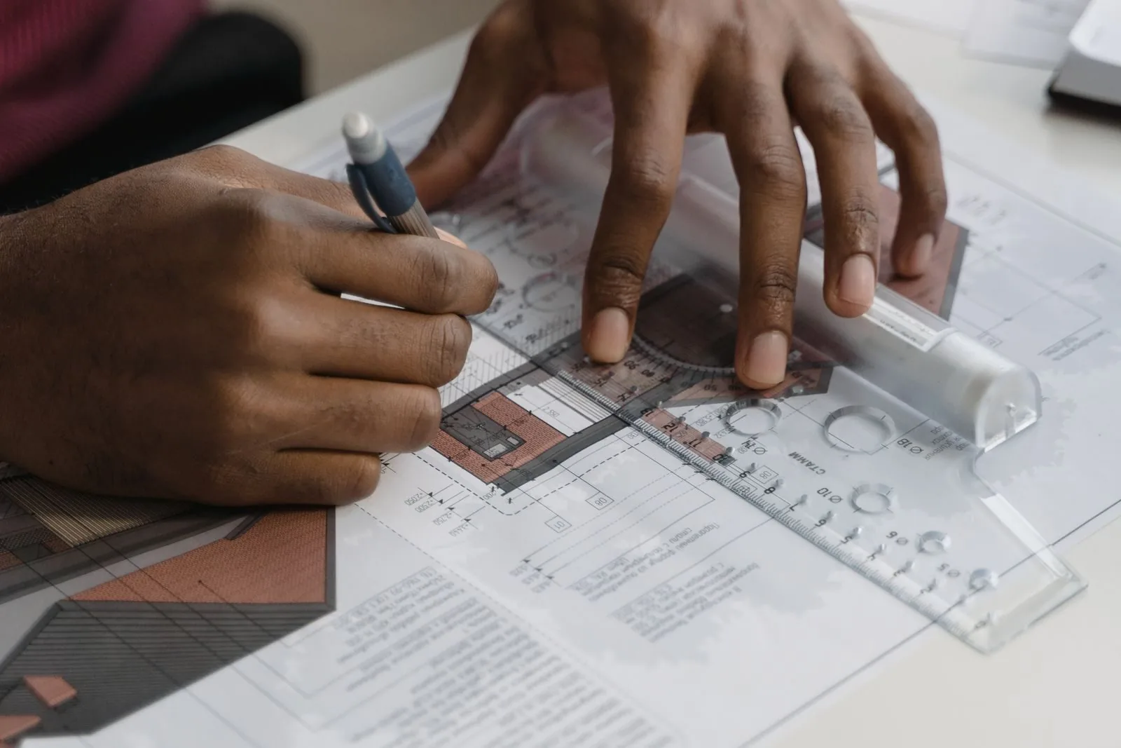Architect drawing building plans with a ruler and pencil