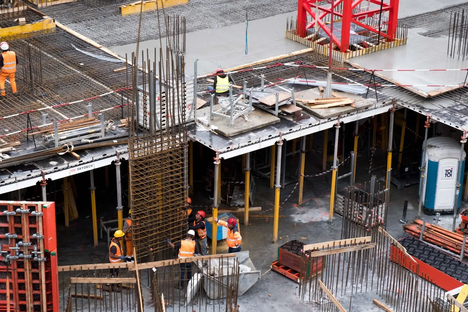 Construction workers on a steel and rebar frame at a building site